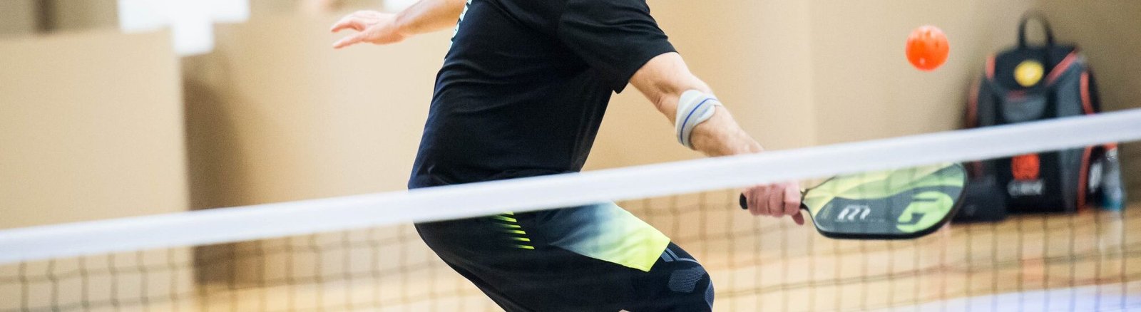 Image d'un joueur de pickleball qui frappe une balle de pickleball.